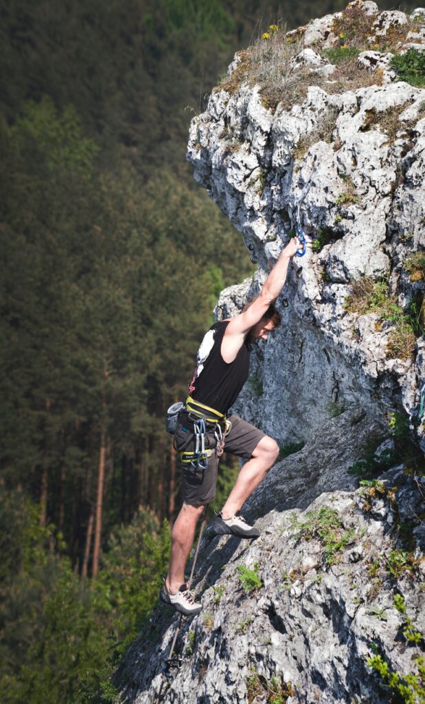 man climbing a challenging mountain